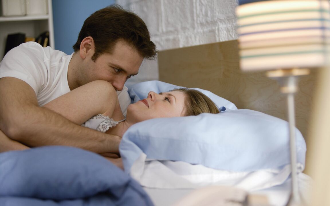 μια γυναίκα στο κρεβάτι με έναν άντρα που έχει διευρύνει το πέος του
